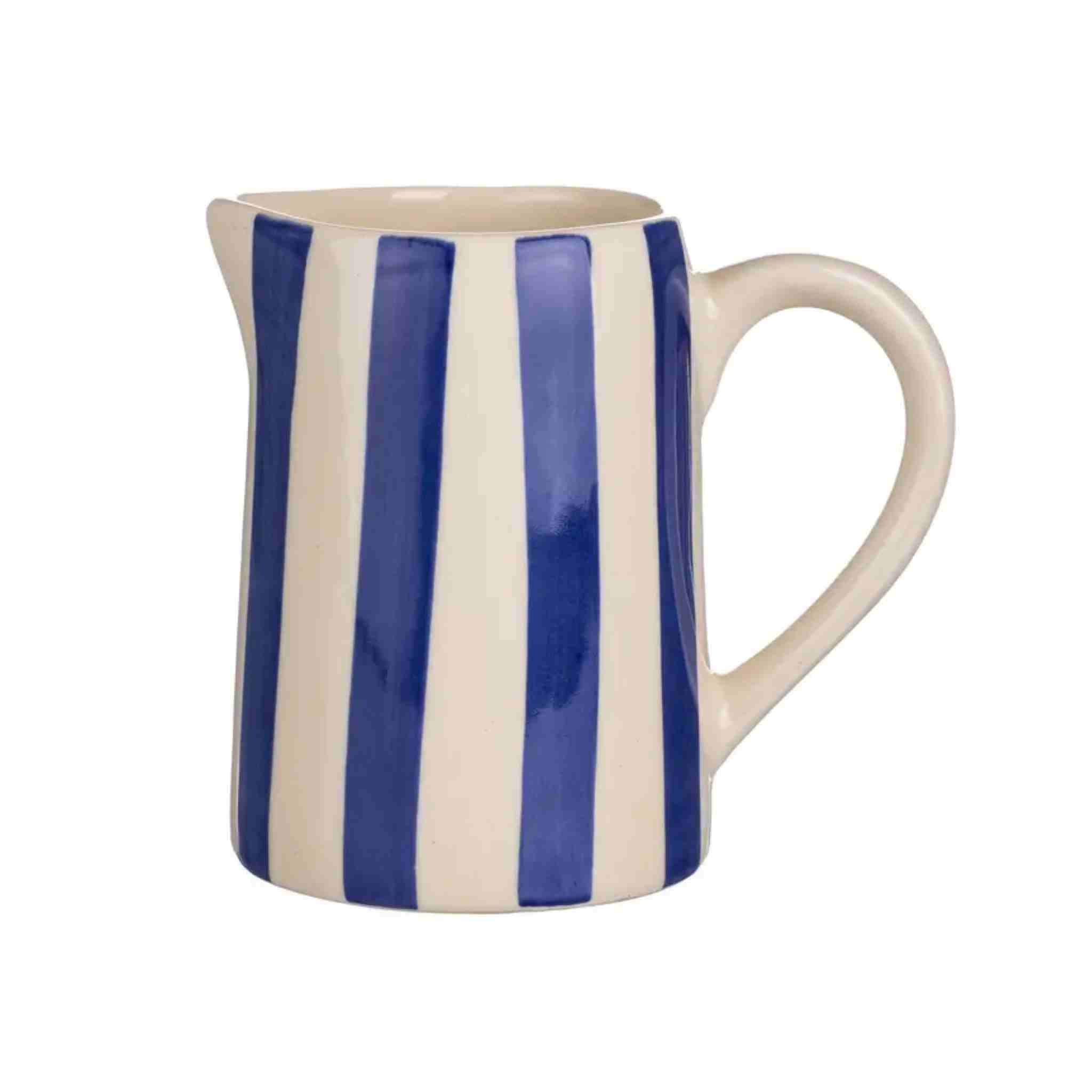 A ceramic pitcher with a cream-colored body and handle, decorated with bold vertical blue stripes