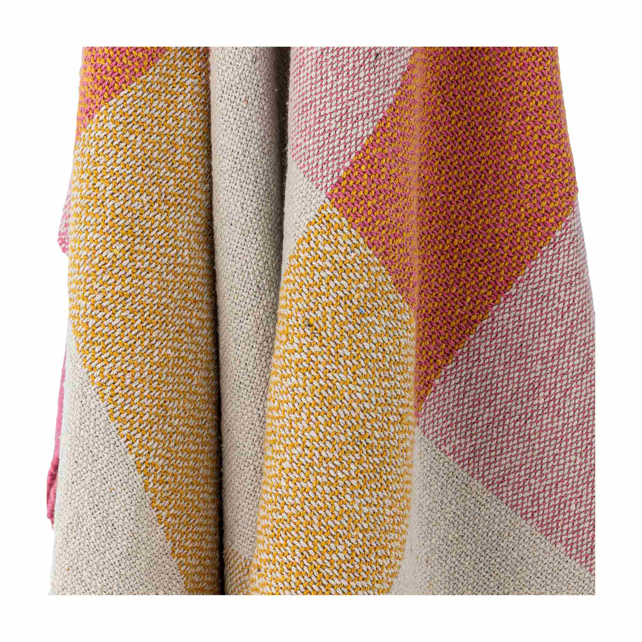 Close-up of a textured fabric with geometric pattern in pink, yellow, and beige.