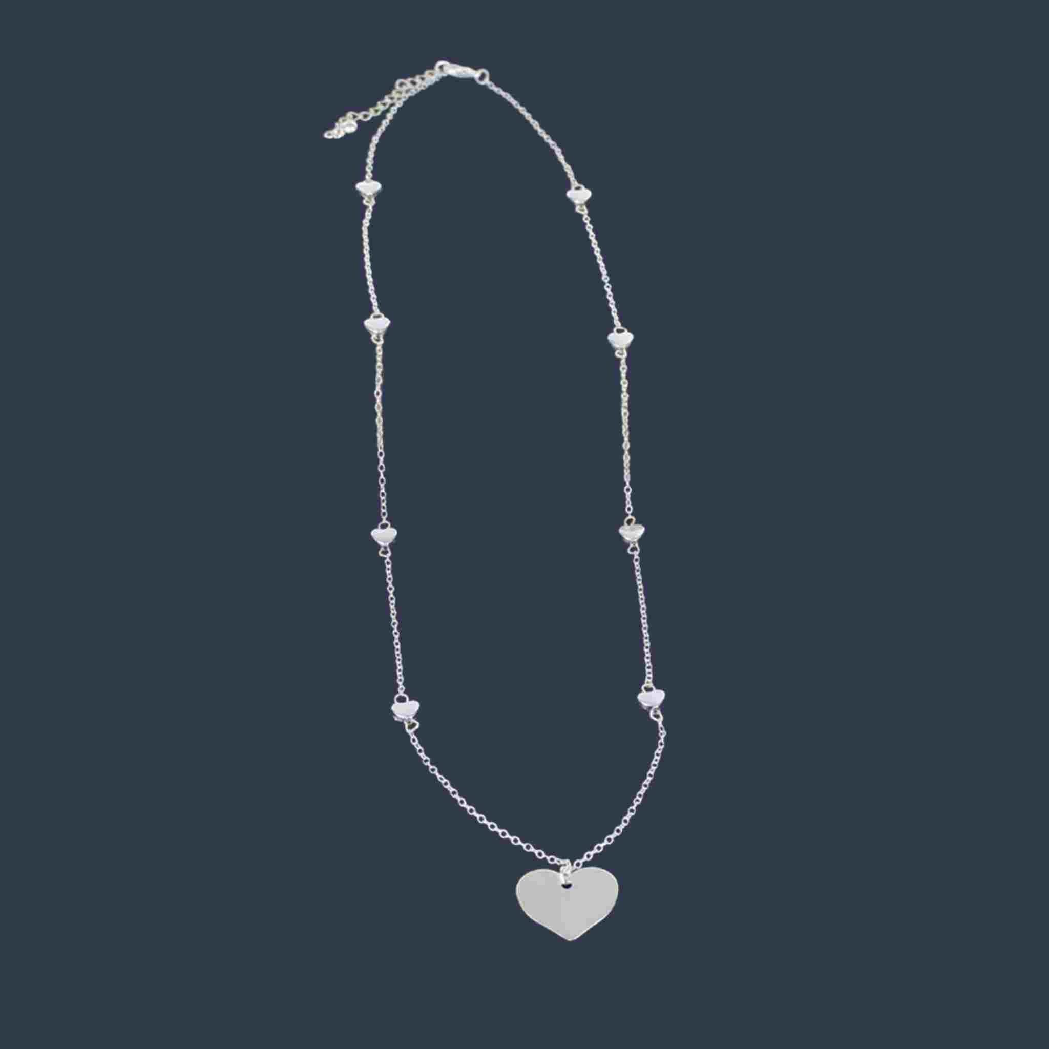 Silver necklace with heart pendant on a dark background