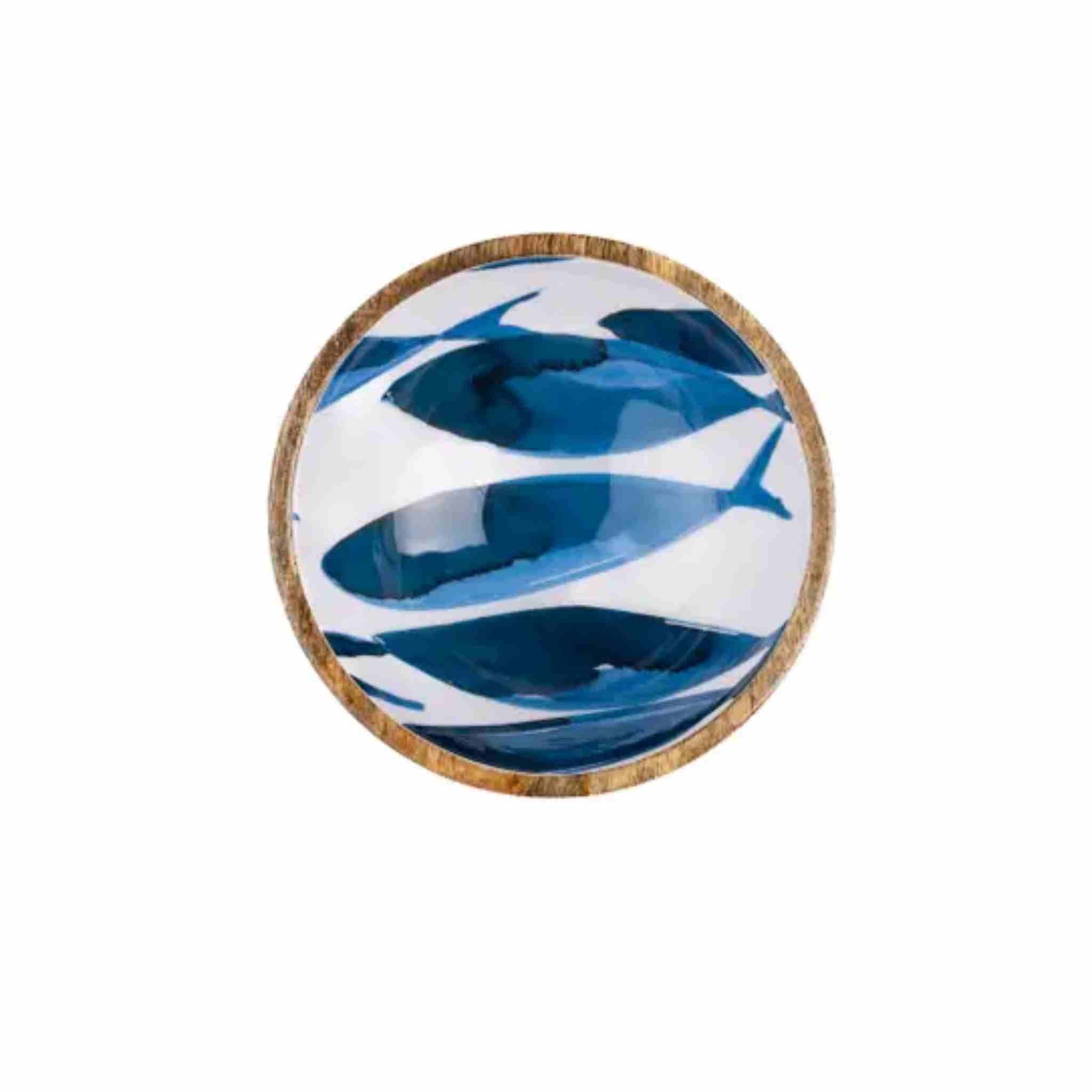 A round decorative bowl featuring a blue and white whale pattern, finished with a natural brown bamboo rim,