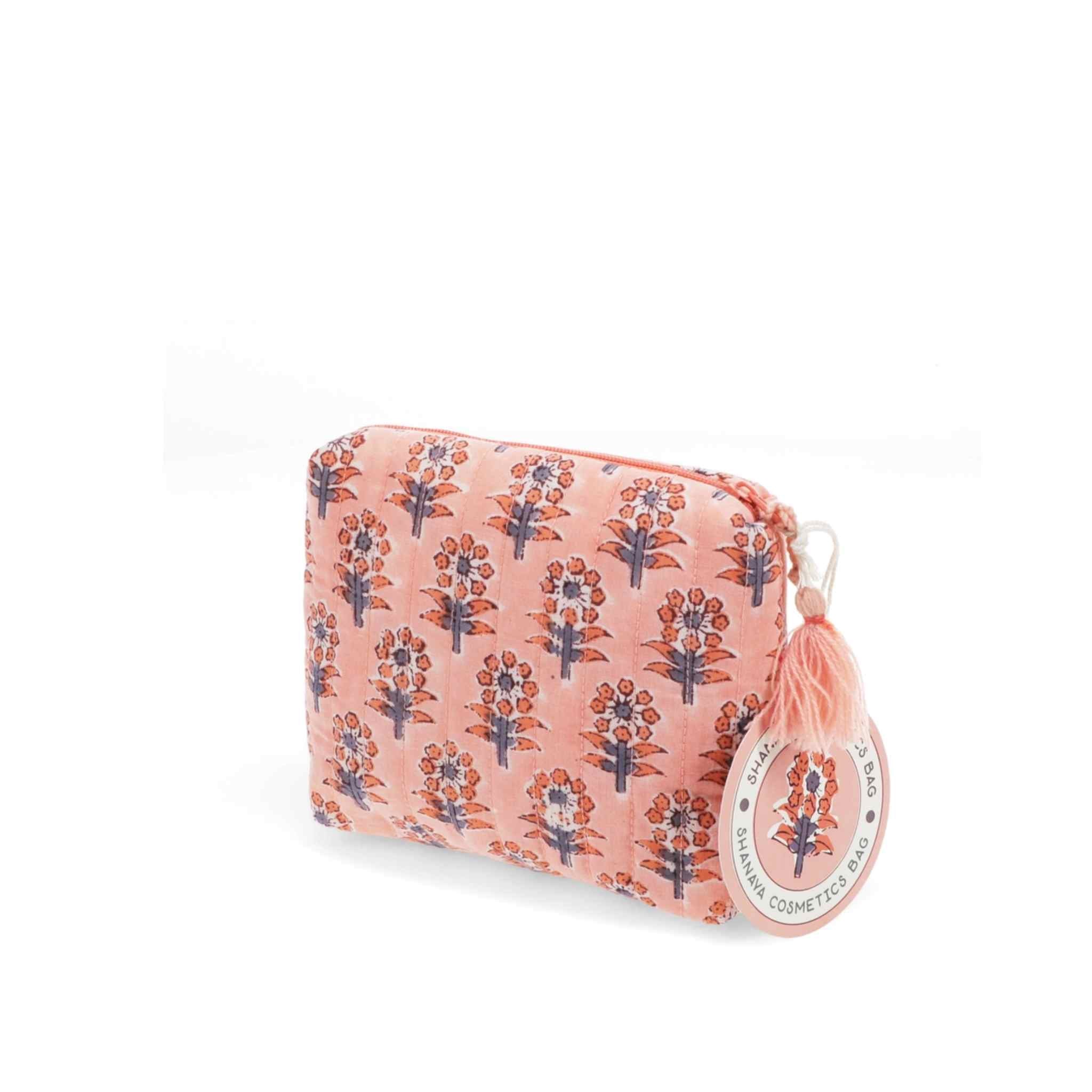 Pink floral patterned pouch with a tassel on a white background