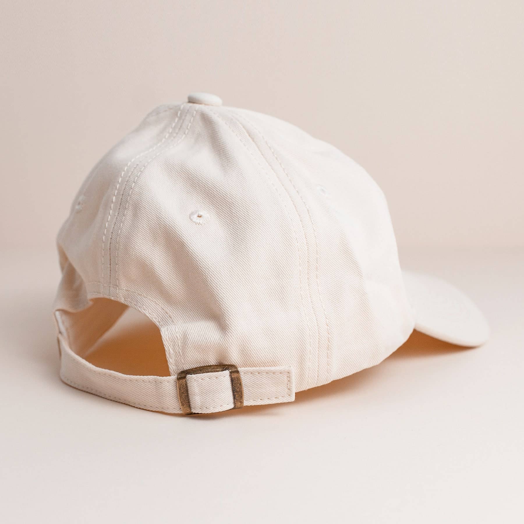 White baseball cap on a beige background