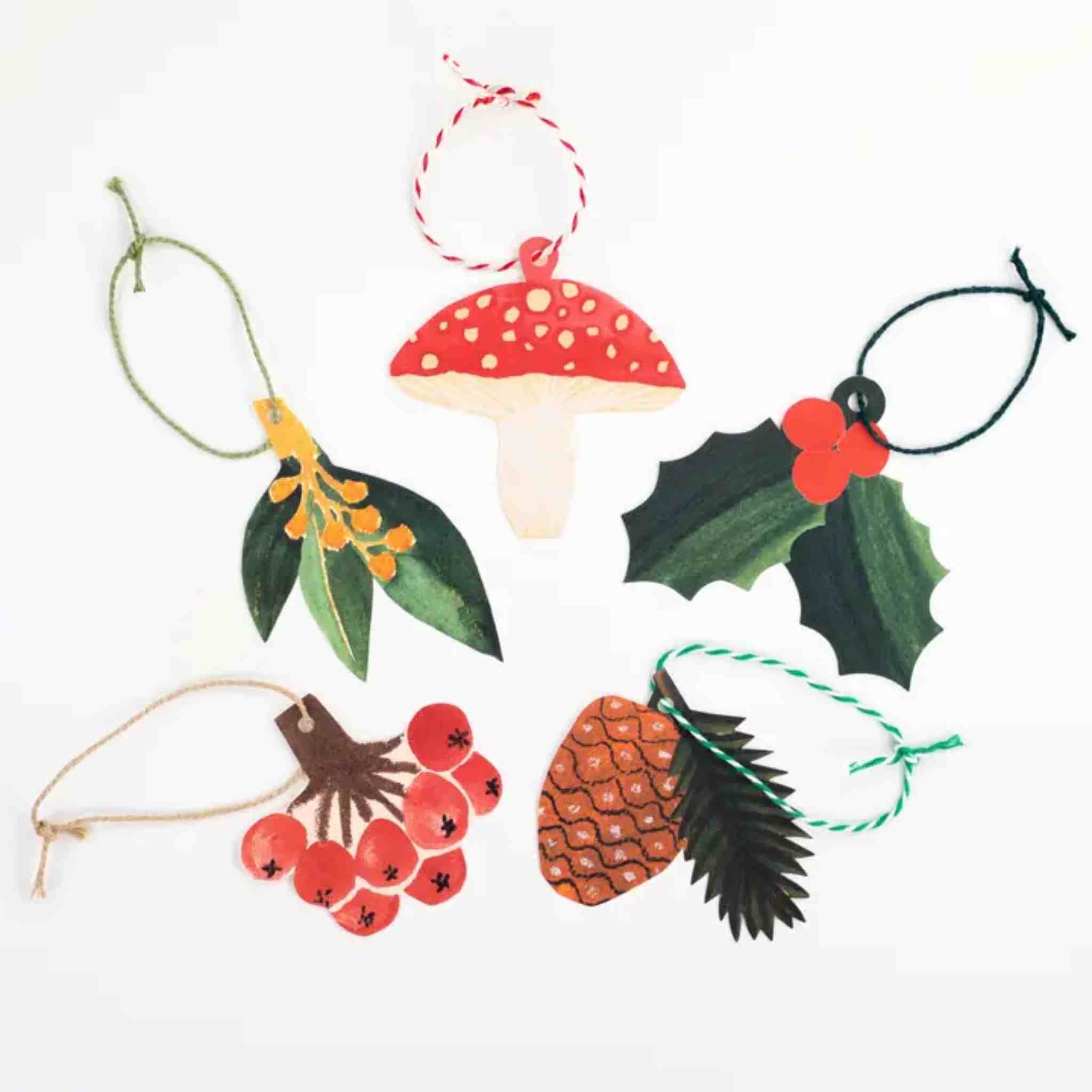 Set of Christmas-themed decorations including mistletoe, mushrooms, holly leaves, and berries on a white background.