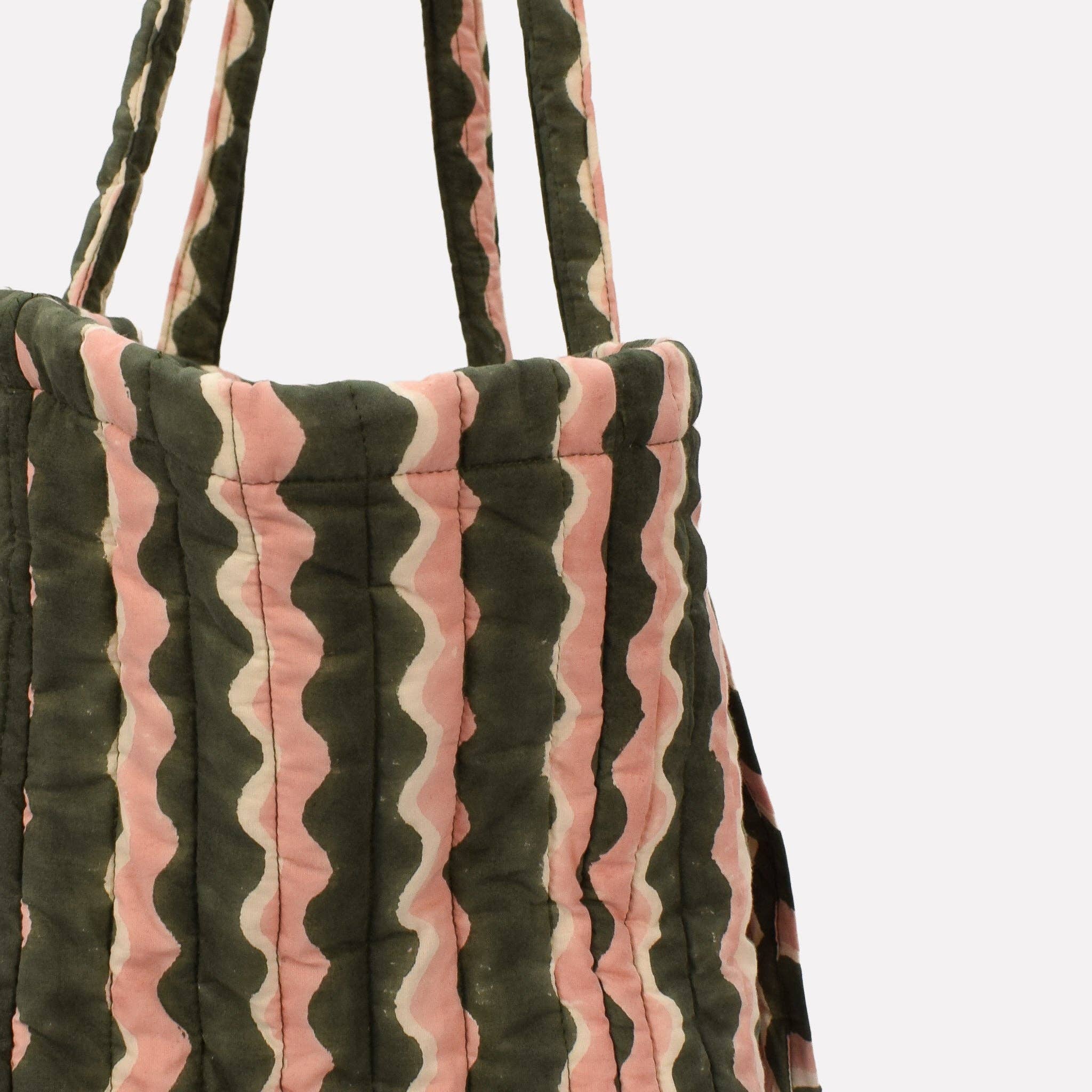 Quilted tote bag with wavy pattern on a white background