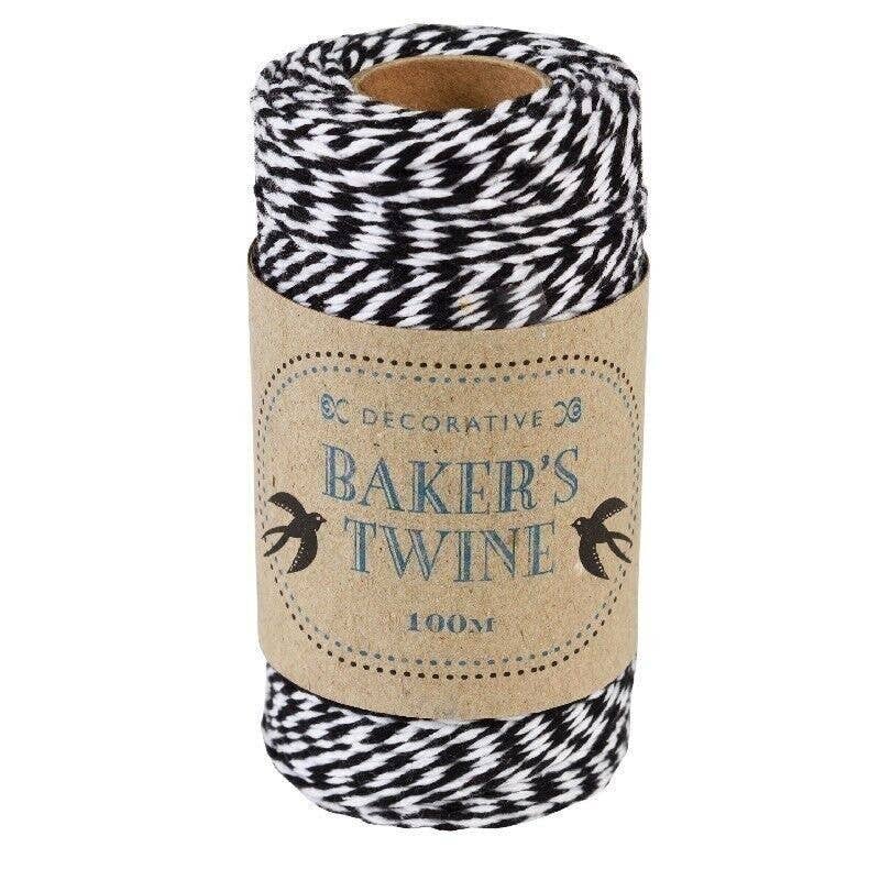 Roll of black and white baker's twine with a decorative label on a white background