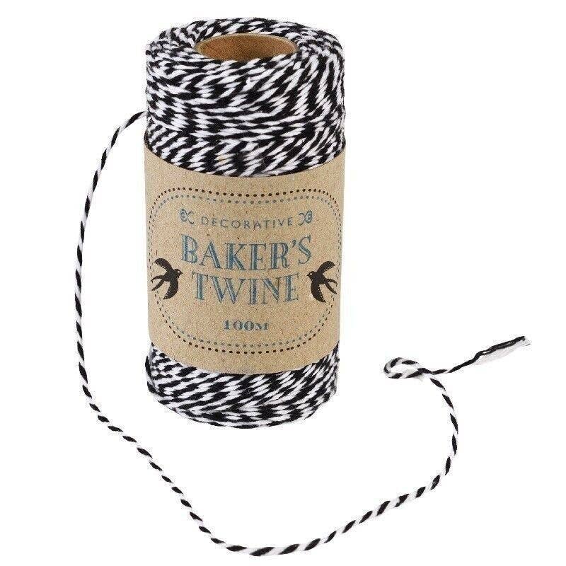 Spool of black and white baker's twine with a decorative label on a white background