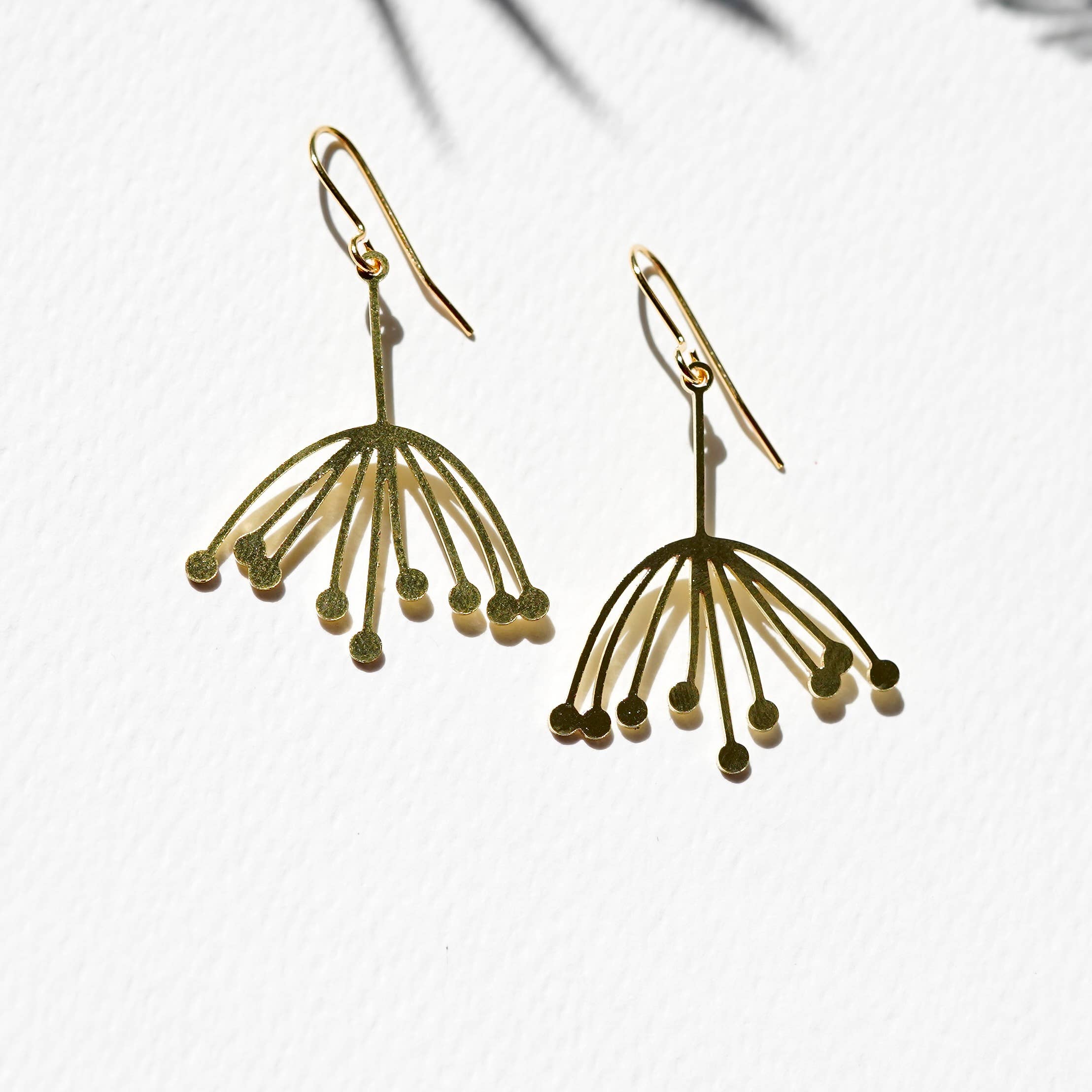 Gold earrings with a unique design on a light background