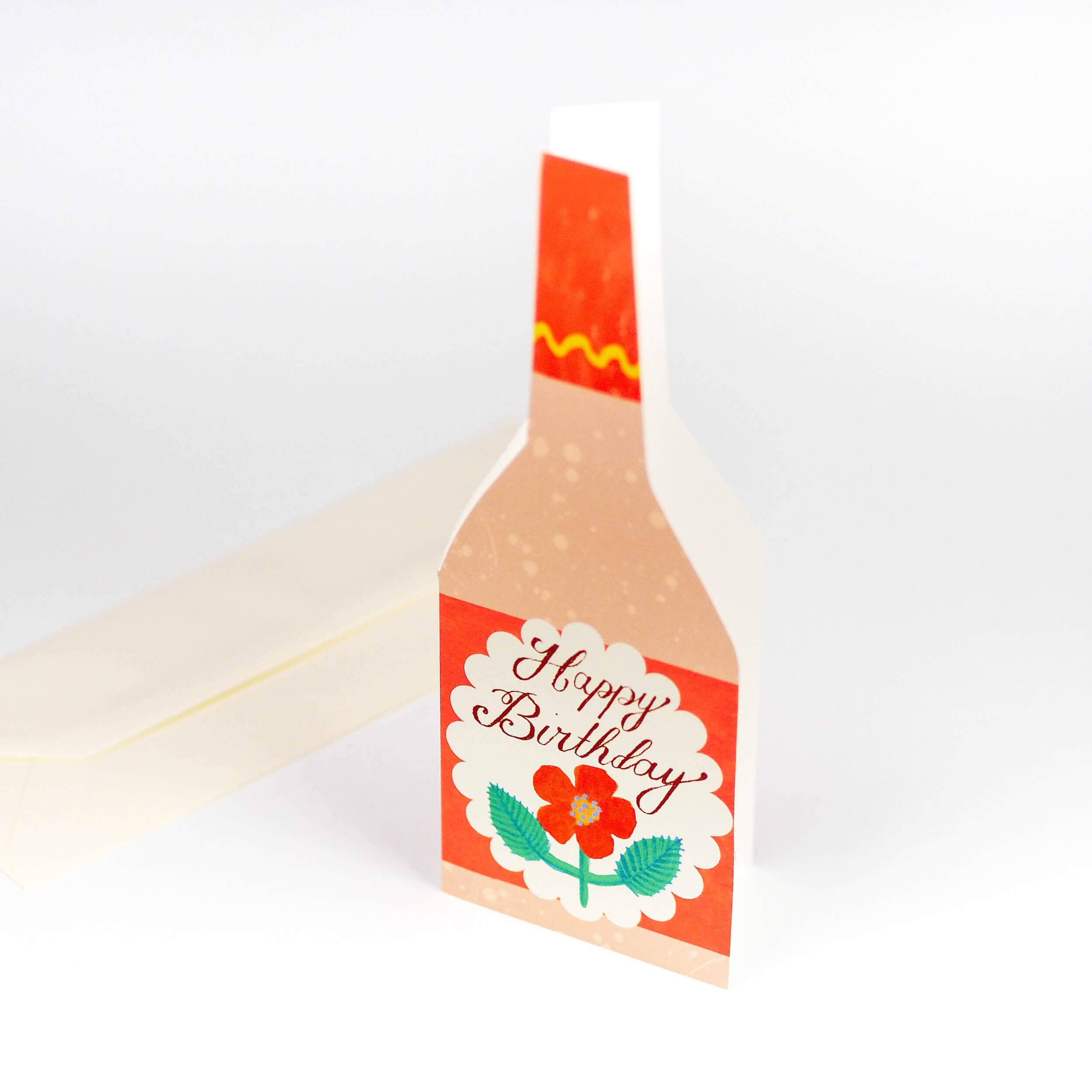 Bottle-shaped birthday card with red label and floral design on a white background