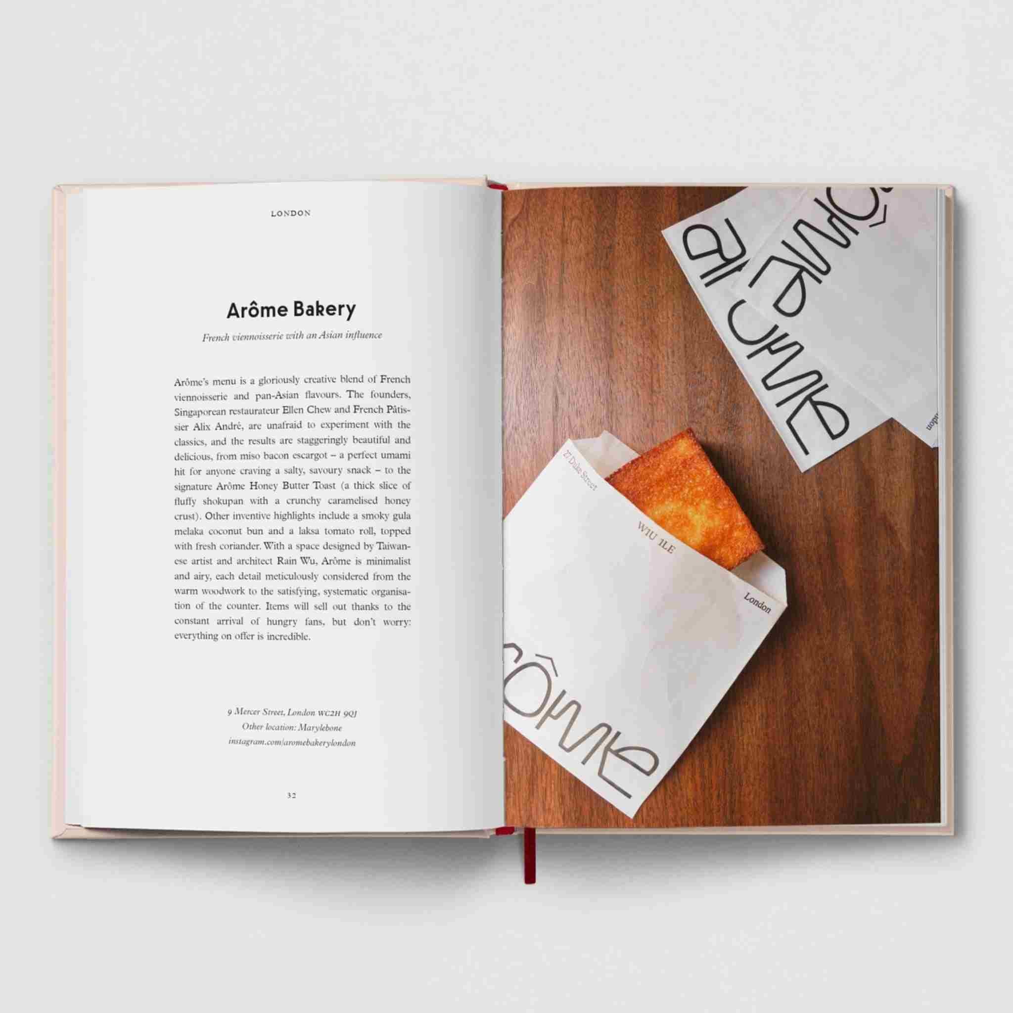 Open book with a pastry on a wooden surface