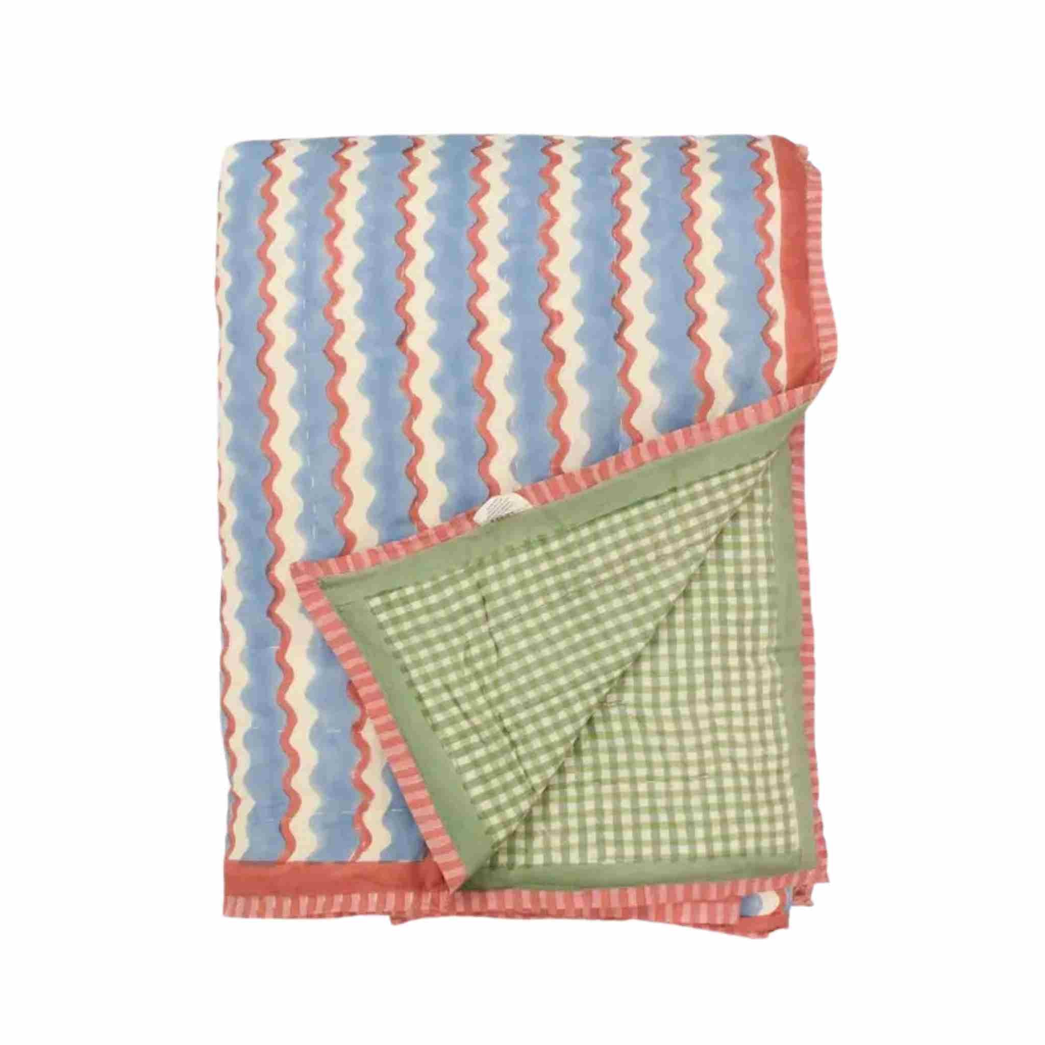 Folded blanket with colorful zigzag pattern on a white background