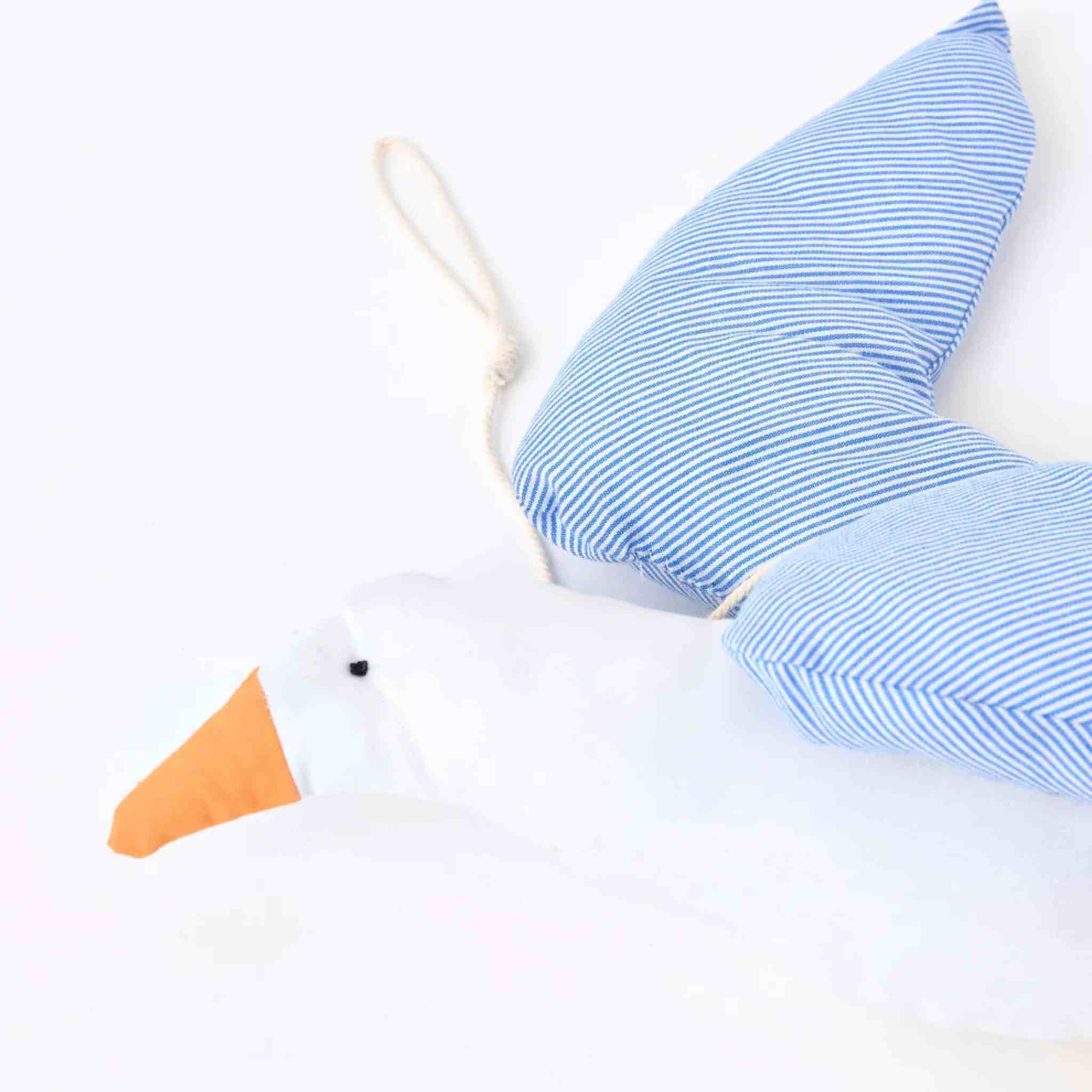 White seagull with blue and white striped wings on a light background
