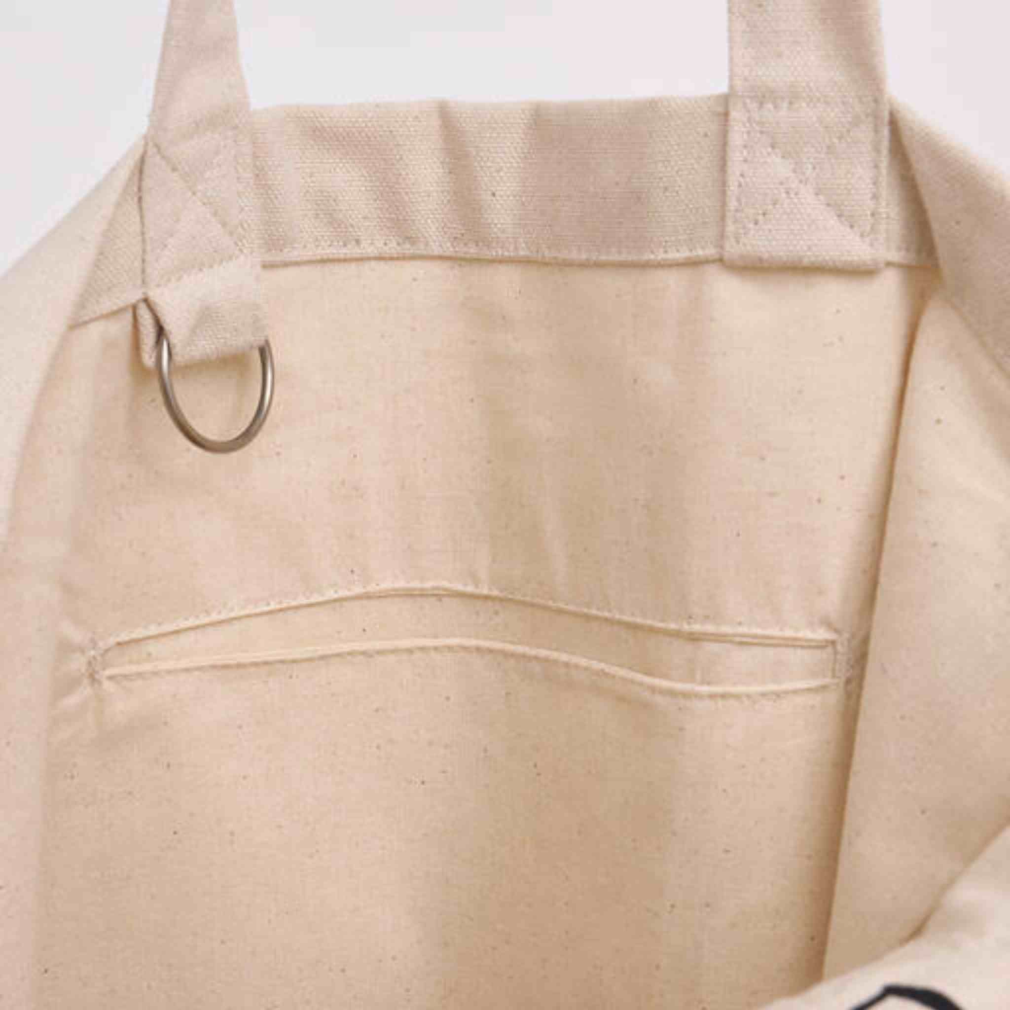 Close-up of a beige apron with a pocket and strap on a light background