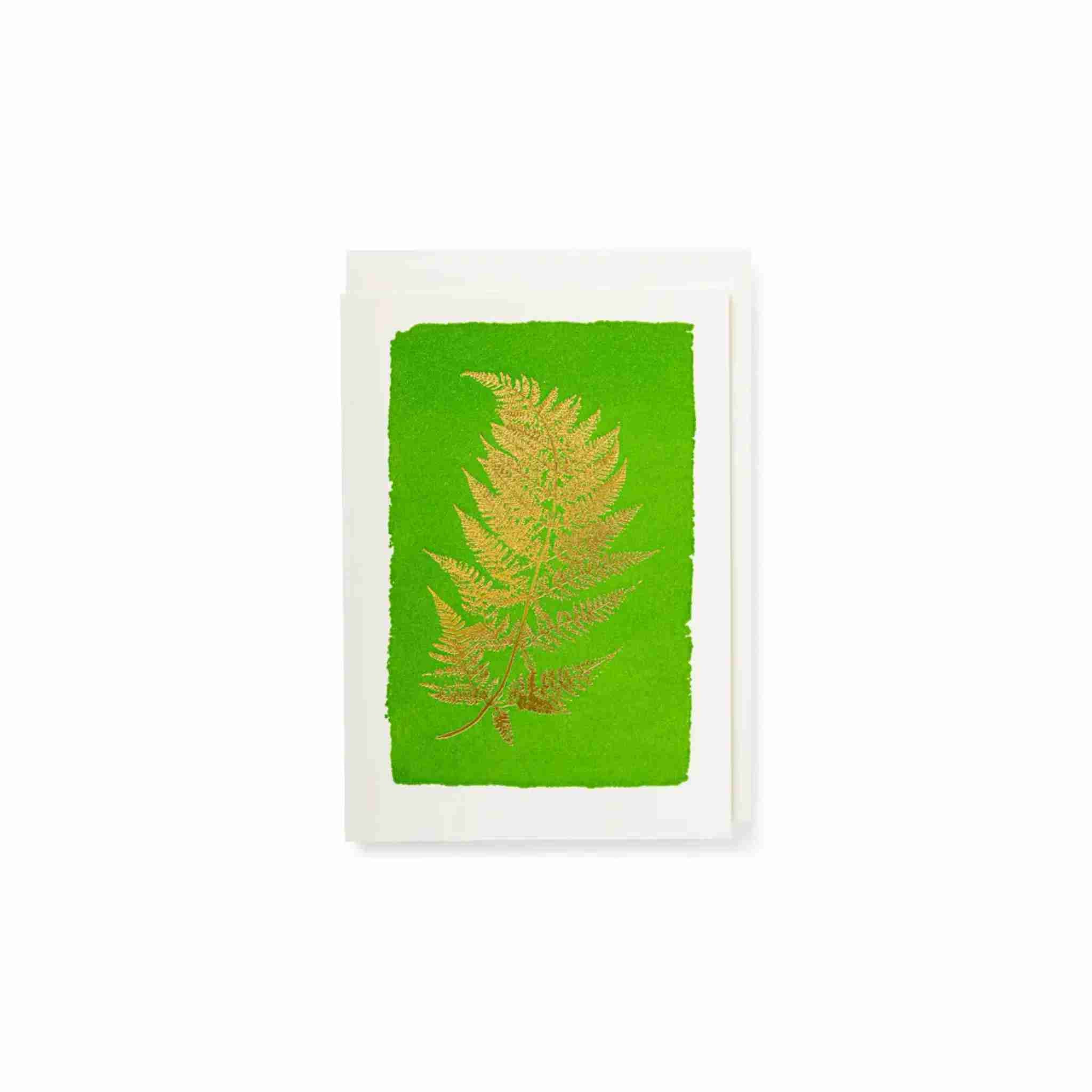 Green card with gold fern design on a white background