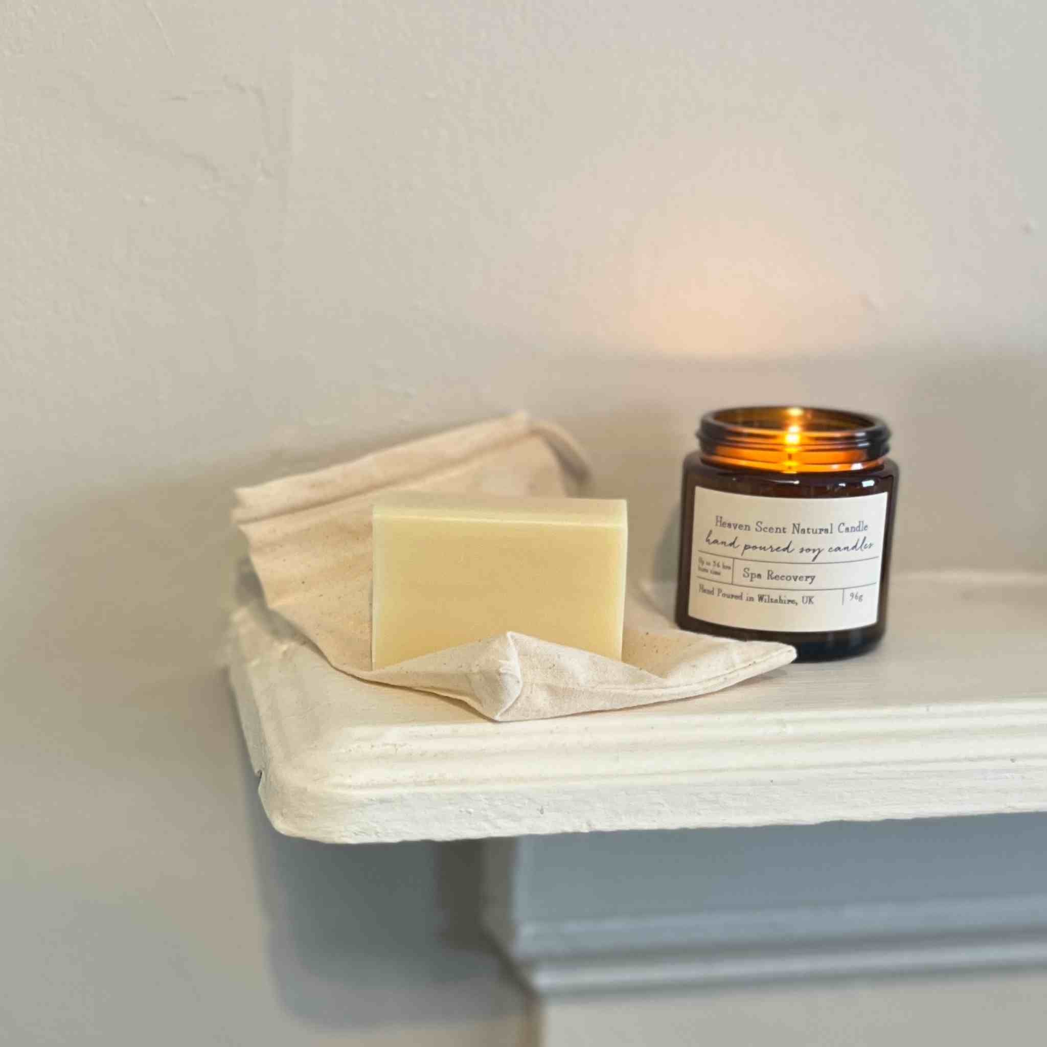 Candle and soap on a white surface with a neutral background