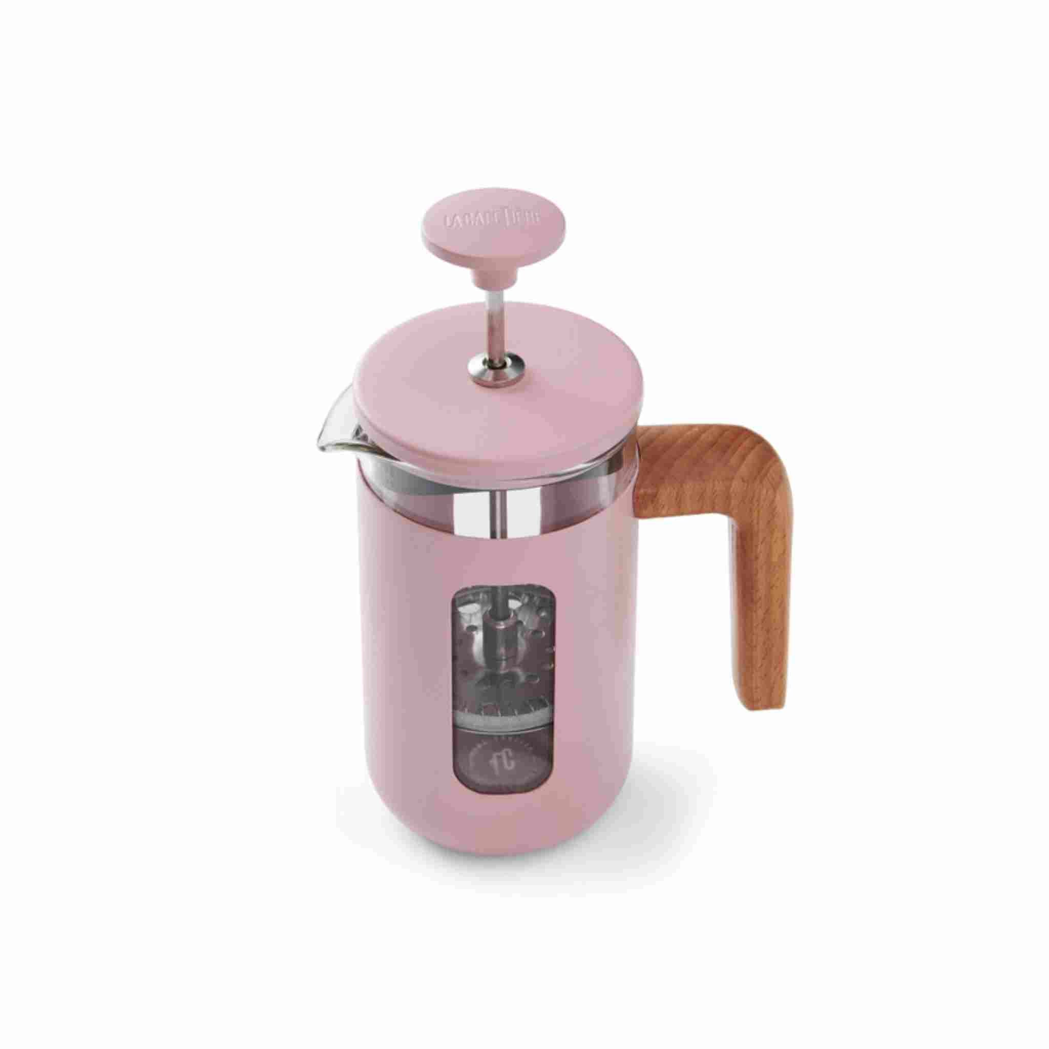Pink French press coffee maker with wooden handle on a white background