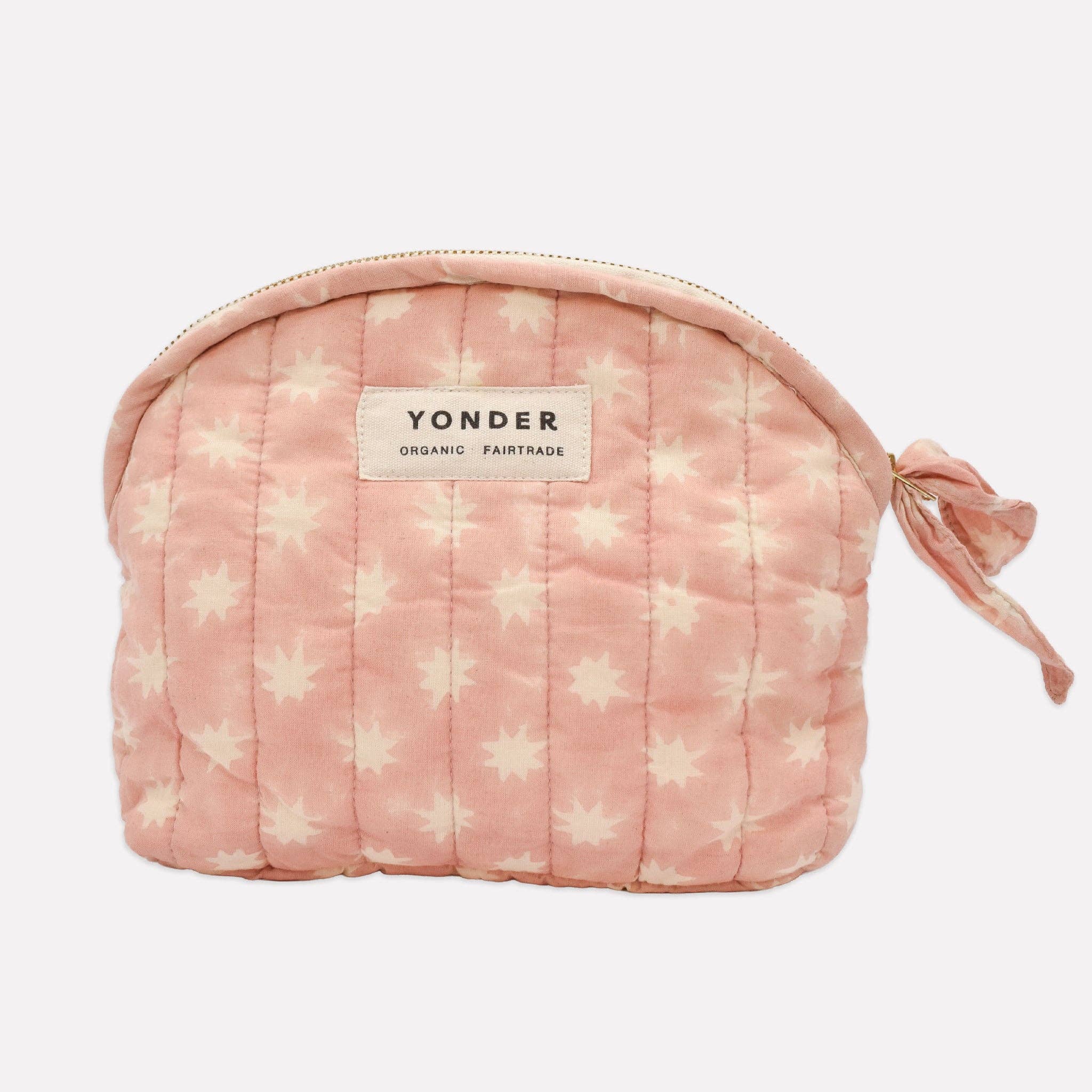 A pink quilted cosmetic pouch with a white star pattern