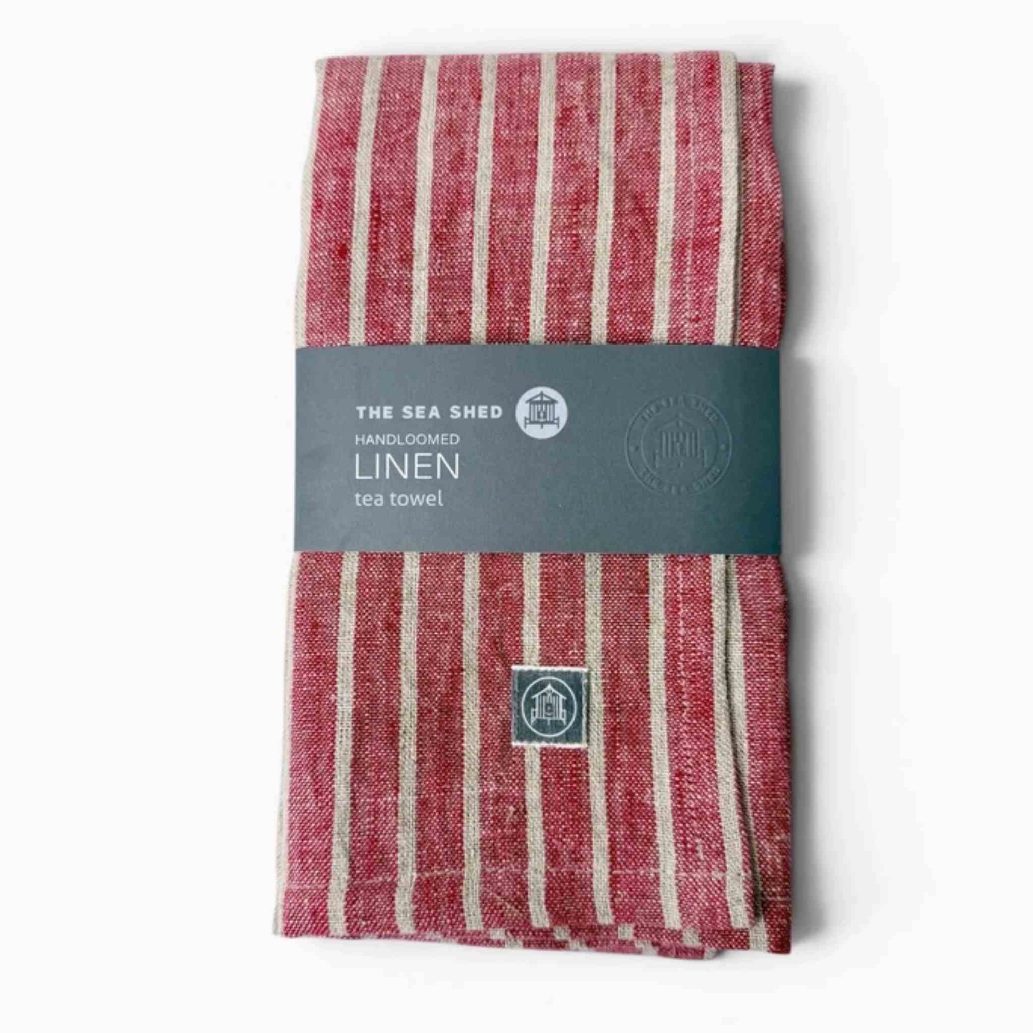 A folded Red Breton Stripe Linen Towel with grey sleeve