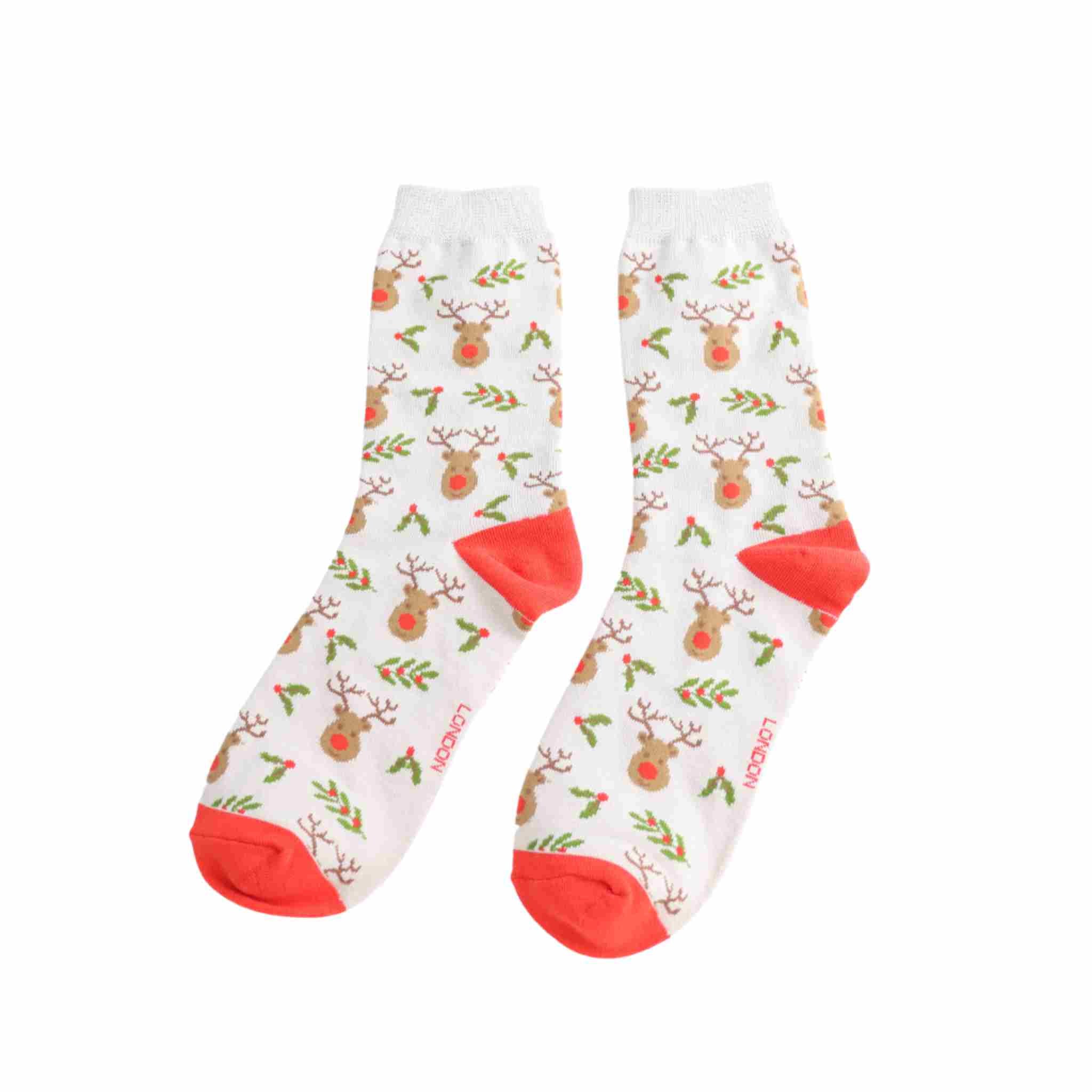 Pair of light grey socks with reindeer and holly pattern on a white background