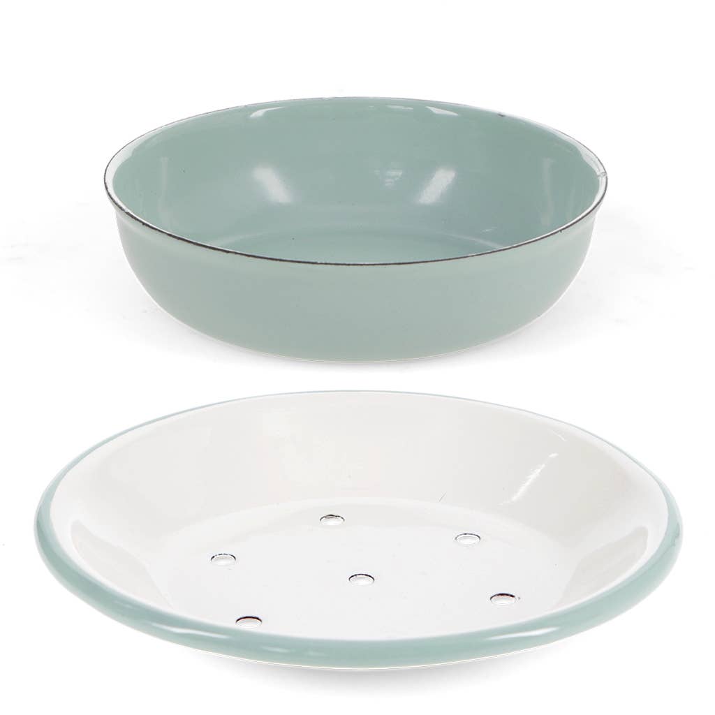 A two-piece ceramic dish set featuring a wide, shallow round bowl in a pale sage green glaze with a thin dark rim, and a matching round plate with a white interior and a rim of the same sage green glaze. The plate has several small drainage holes.