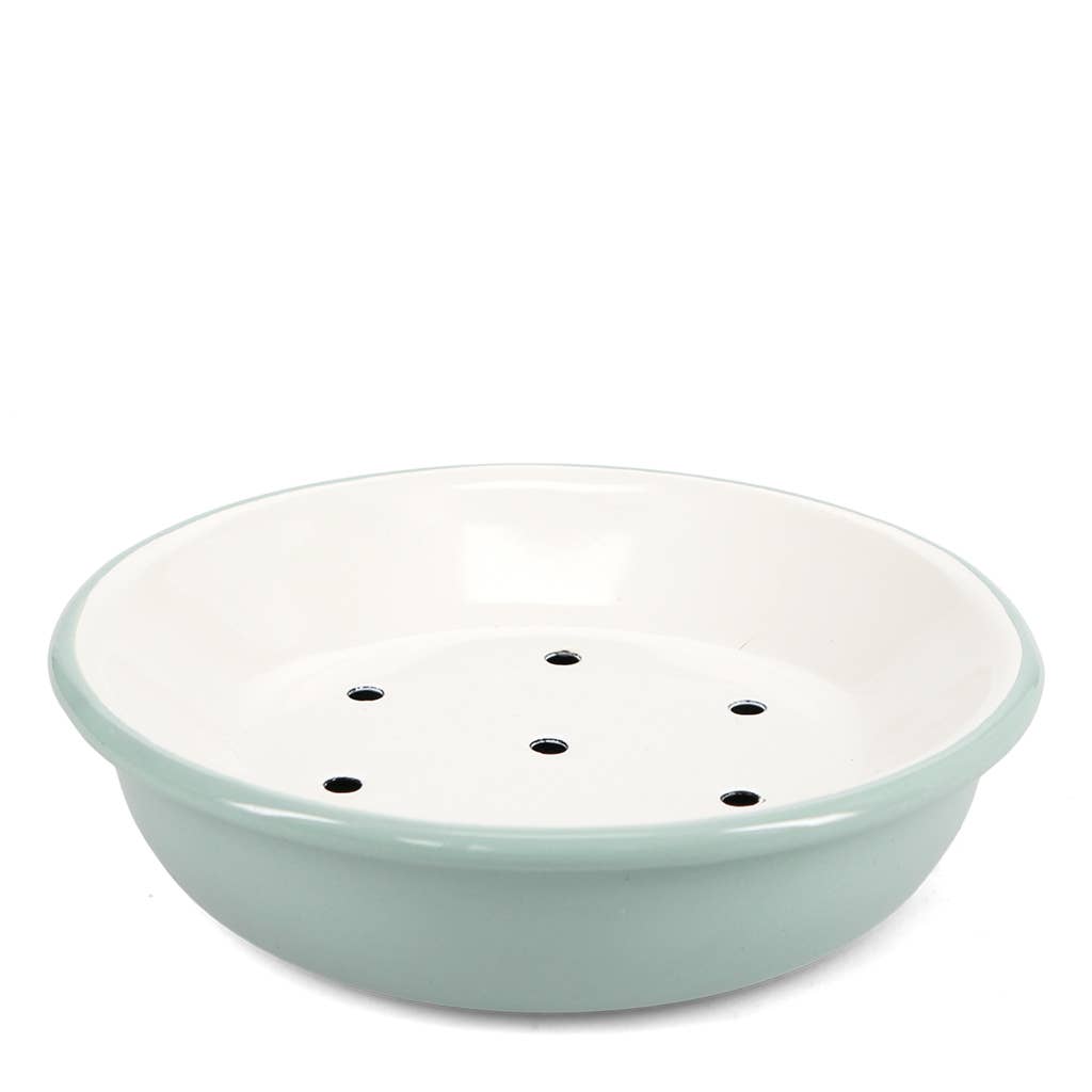 A round ceramic bowl with a light sage green exterior and a white interior, featuring six small drainage holes on the bottom, set against a plain white background.