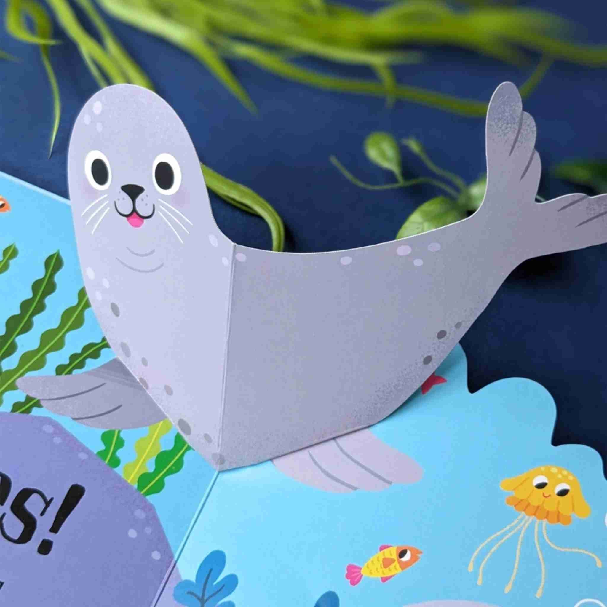 Cartoon seal on a blue background with underwater elements