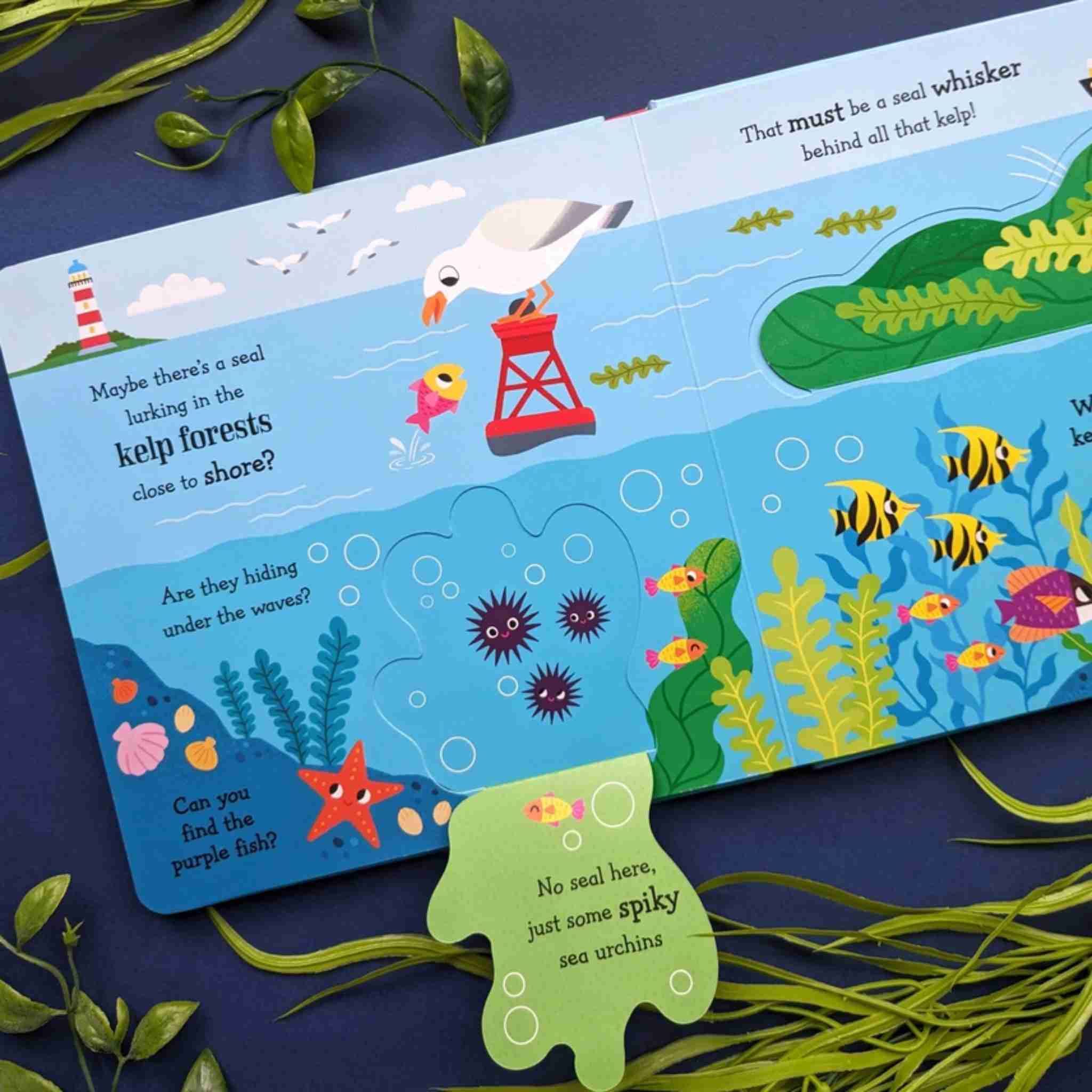 Children's book with an underwater scene featuring fish, a seagull, and kelp forests on a blue background.