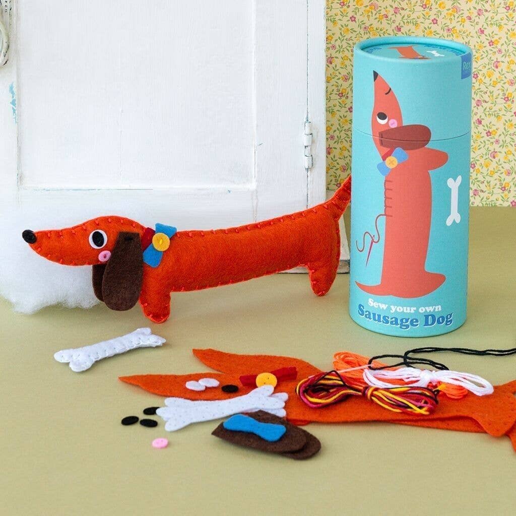 Red dachshund toy with accessories and a blue cylindrical packaging on a beige surface.