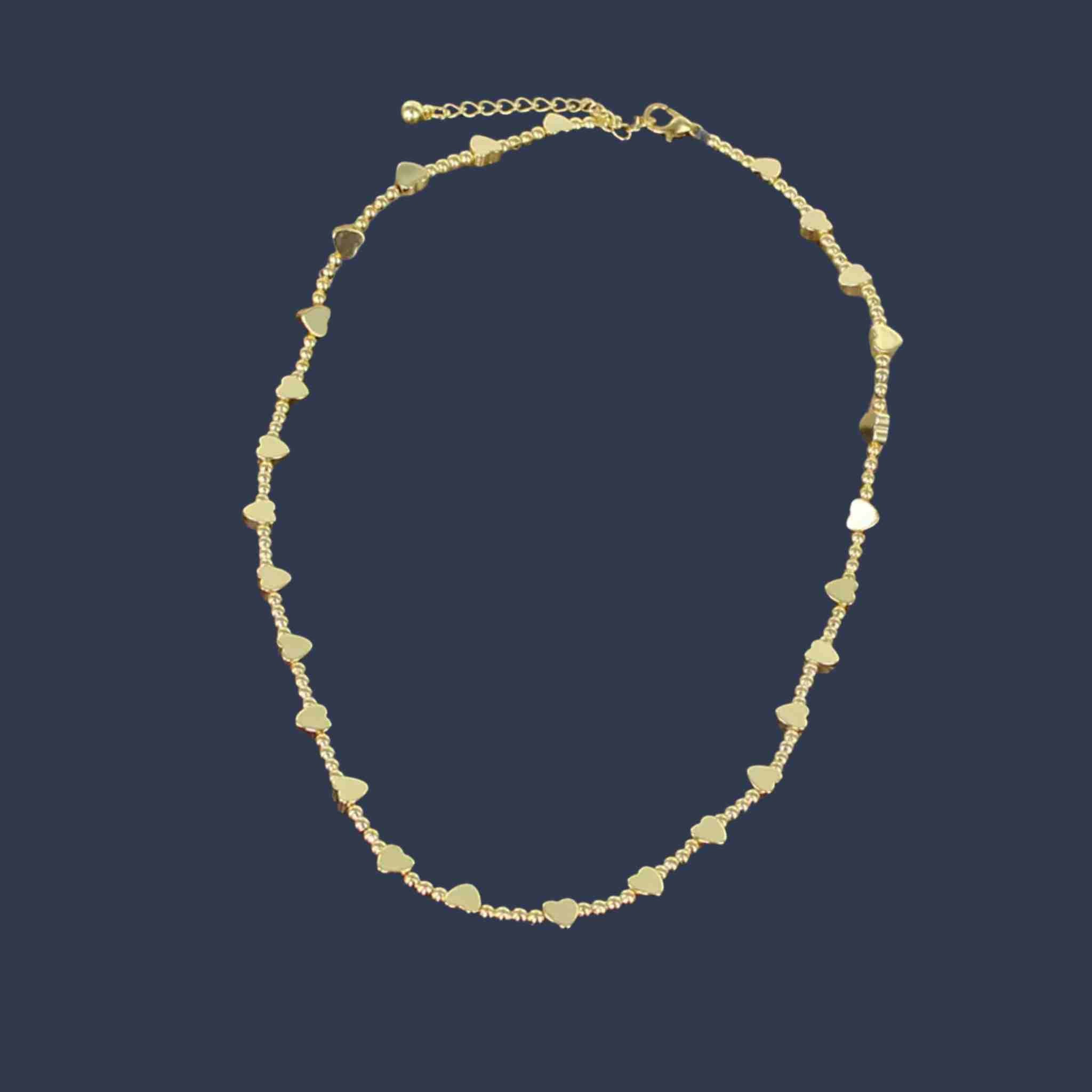 Gold necklace with heart-shaped beads on a dark blue background