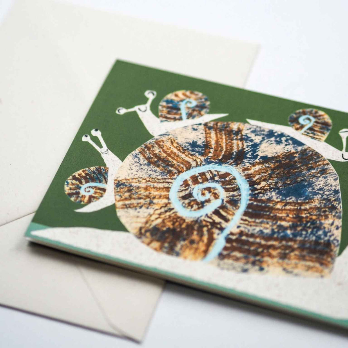 Greeting card with a snail design on a green background