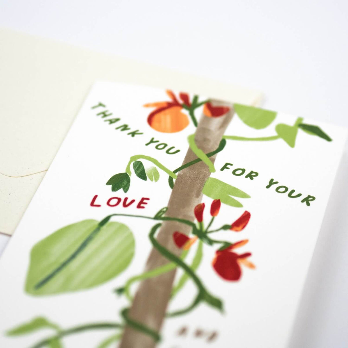 Greeting card with floral design and text 'Thank you for your love', featuring a hand holding flowers.