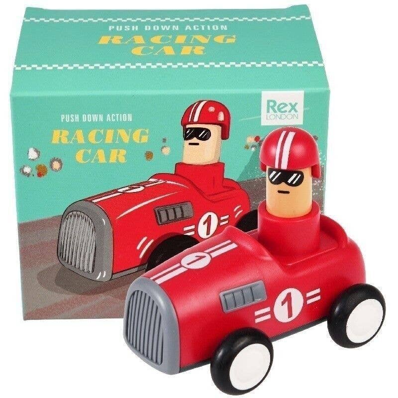 Toy racing car with driver figure in front of its packaging